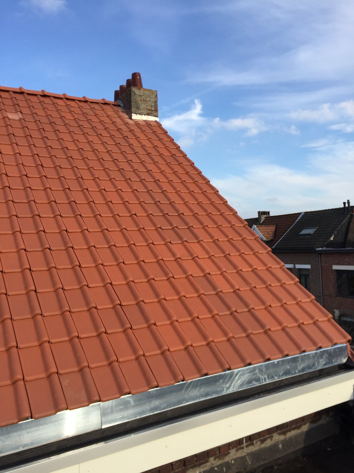 Dak met rode pannen en een zinken boord
