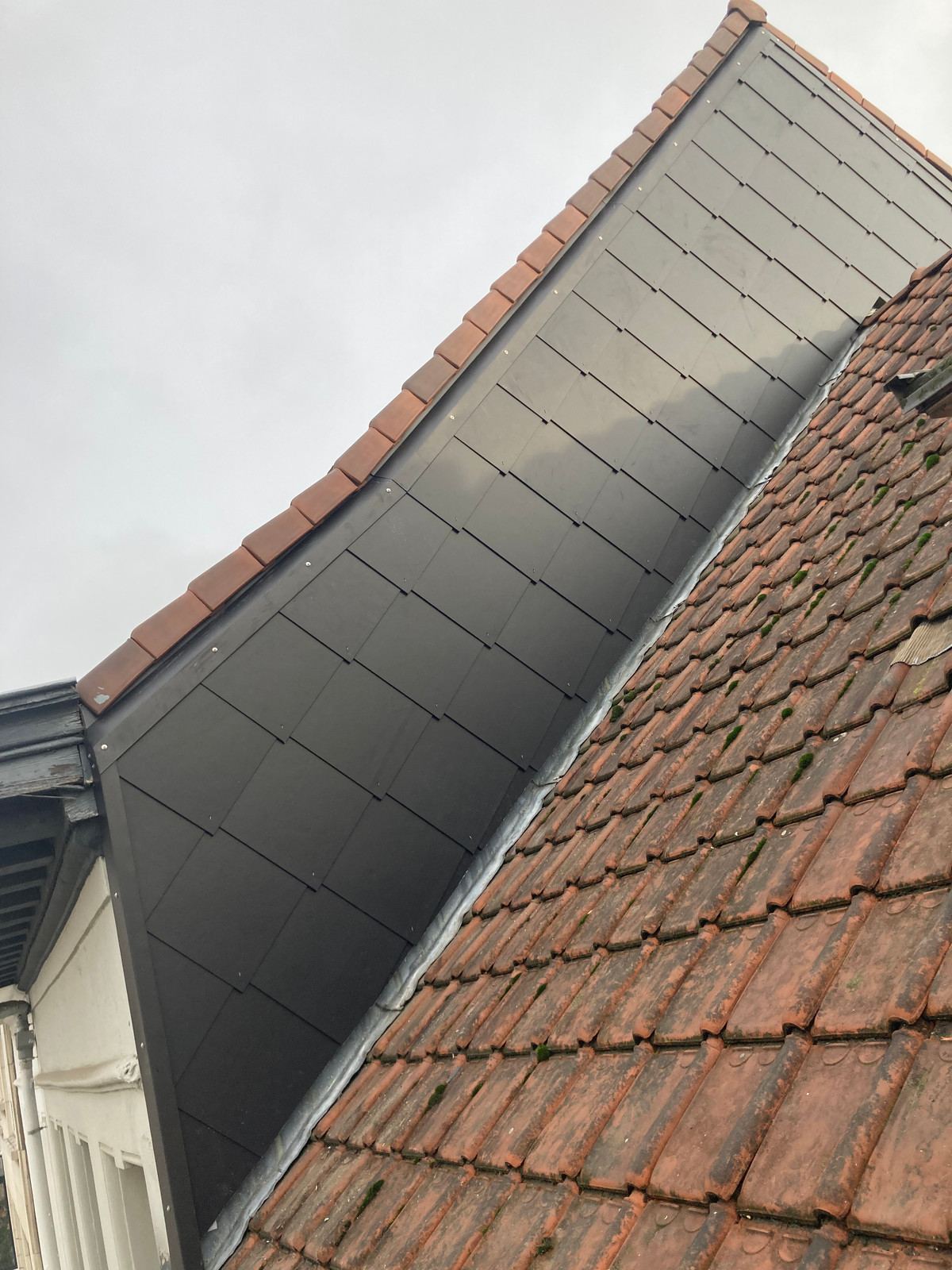 Dakkapel met zinken bekleding naast een pannendak